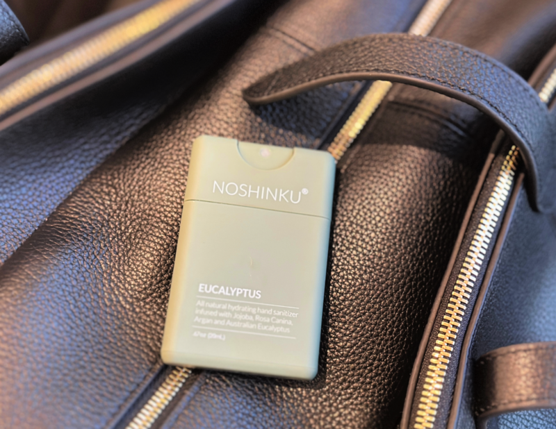 The Ultimate Packing List for Europe: By a Frequent Traveler noshing hand sanitizer on top of the quince leather weekender