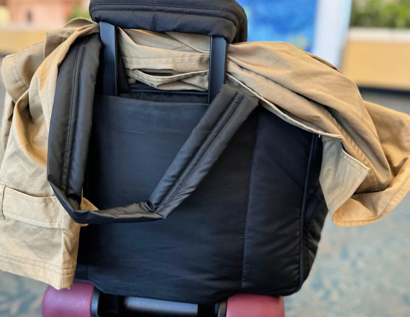 trolley sleeve of the calpak luka duffel - on the quince carry-on with the fabletics cropped trench at west palm airport - summer 2026