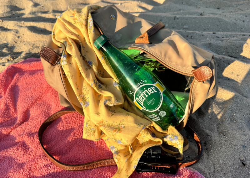 Spring Break Packing List: 10 Must-Have Travel Essentials LONGCHAMO TOTE BAG AND PERRIER WATER ON THE BEACH IN ANTIBES