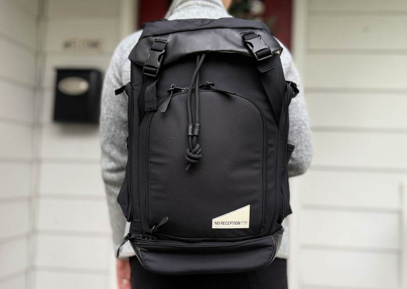 No Reception Club Getaway Bag Review: Easy Travel for Parents lexie wearing the No Reception Club Getaway Backpack Review diaper bag