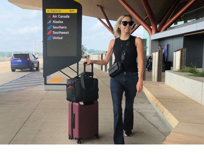 Quince Carry-On Review 2026: Worth It After 4 Real Trips? Ally walking out of Pittsburgh airport with the quince carry on and the calpak luka duffel