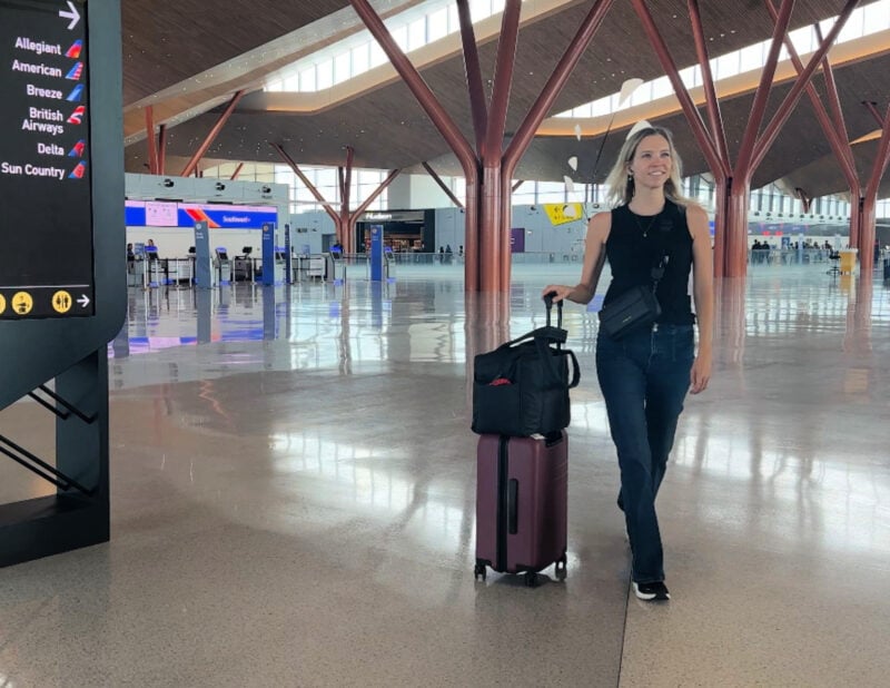 Quince Carry-On Review 2026: Worth It After 4 Real Trips? ally inside Pittsburgh airport with her quince carry-on and calpak luka duffel with bandolier miller crossbody